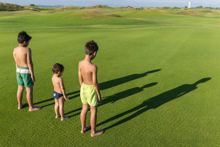 Happy summer vacation for kids on green meadow near seaの写真素材