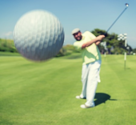 Man playing golf at clubの写真素材