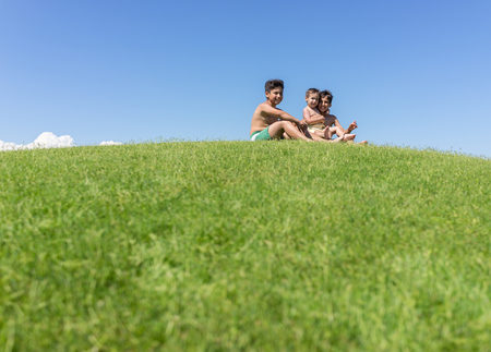 Brothers playing upside down on green meadowの写真素材