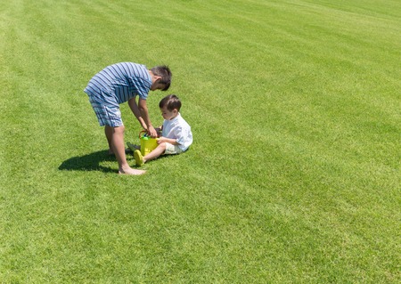 Happy summer vacation for kids on green meadow near seaの写真素材