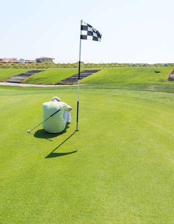 Man playing golf at clubの写真素材