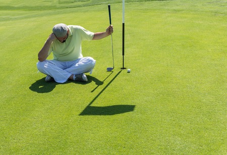Man playing golf at clubの写真素材