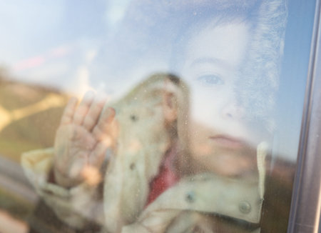 Little boy looking through window