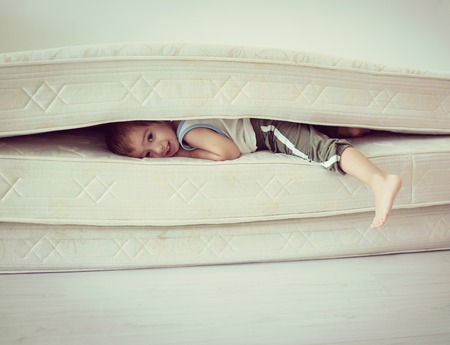 Lovely child laying down on the bedの写真素材