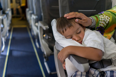 Kid sleeping inside the airplane during the flightの写真素材