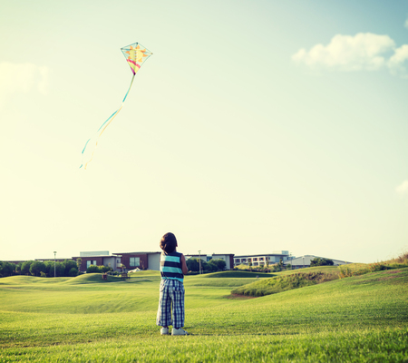 Little boy on summer vacation having fun and happy time flying kite on the sea beachの写真素材