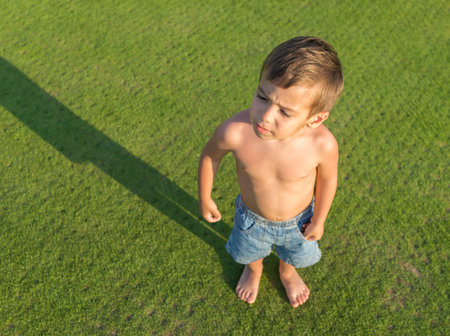 Happy little boy on summer gulf grass terrain having fun and happy timeの写真素材