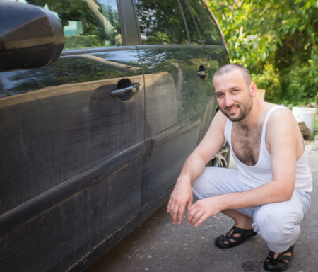 Young father and little boys washing car in summer dayの写真素材