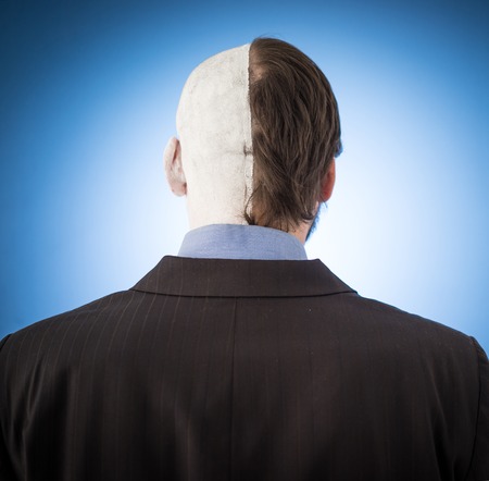 Conceptual two sides face portait photo of a businessmanの写真素材