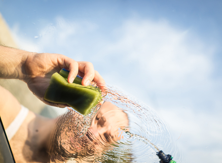 Young father and little boys washing car in summer dayの写真素材