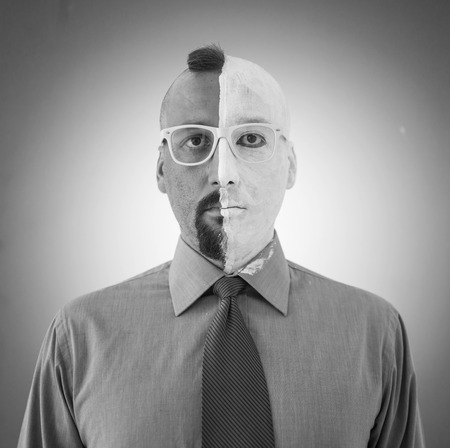 Conceptual two sides face portait photo of a businessmanの写真素材