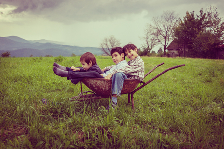Happy kids on field playing with cartの写真素材