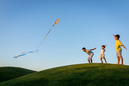 Little boy on summer vacation having fun and happy time flying kite on the sea beachの写真素材