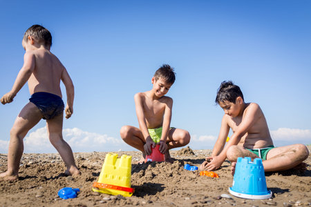 Playful kids on summer beach sand vacation having fun and happy timeの写真素材