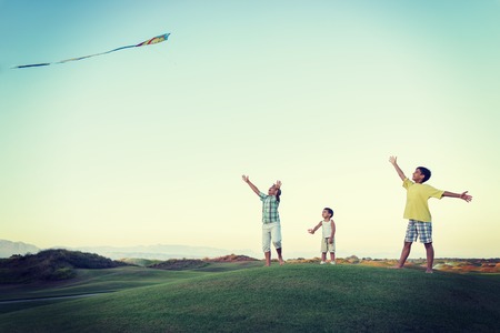 Little boy on summer vacation having fun and happy time flying kite on the sea beachの写真素材