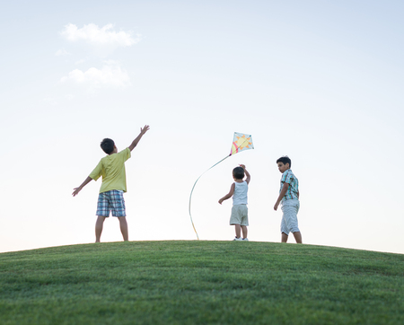 Little boy on summer vacation having fun and happy time flying kite on the sea beachの写真素材