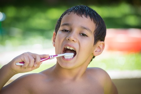 Happy children on summer garden having fun and happy time brushing teeth after outdoor bathの写真素材