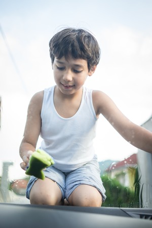 Young father and little boys washing car in summer dayの写真素材