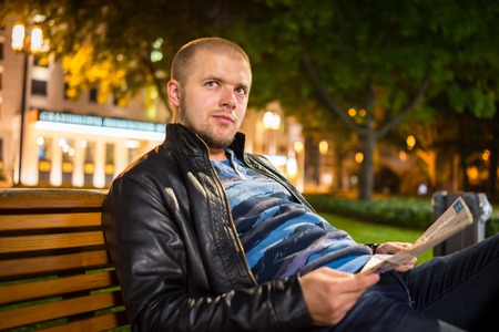 Handsome young hipster outside in the night cityの写真素材