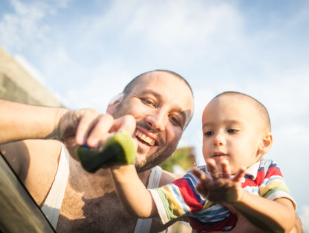 Young father and little boys washing car in summer dayの写真素材