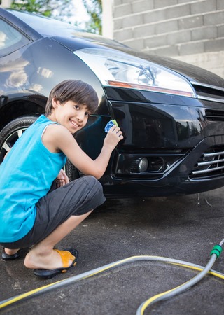 Young father and little boys washing car in summer dayの写真素材