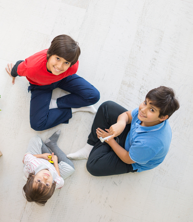Kids on the floor together in new home top viewの写真素材