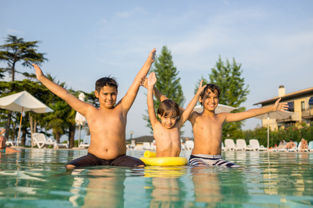 Young boy kid child splashing in swimming pool having fun leisure activityの写真素材