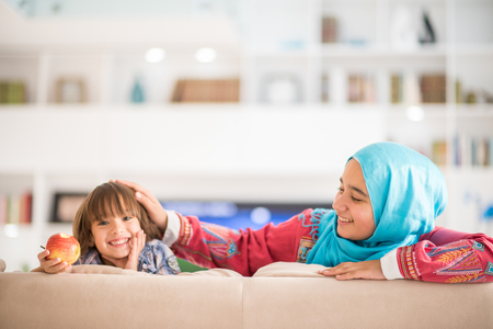 Young woman with little kid at homeの写真素材