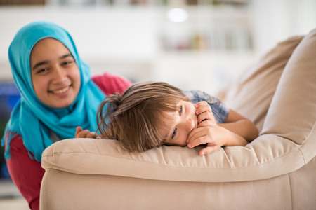 Young woman with little kid at homeの写真素材