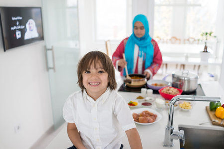 Muslim traditional woman with little son in modern white kitchenの写真素材