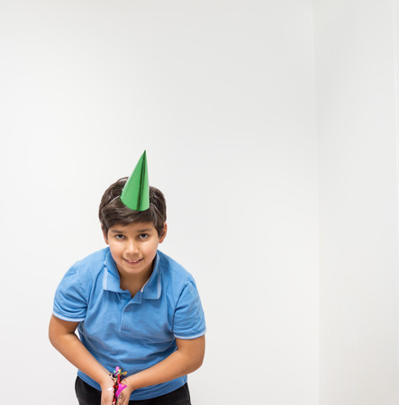 Happy kid celebrating party with blowing confettiの写真素材