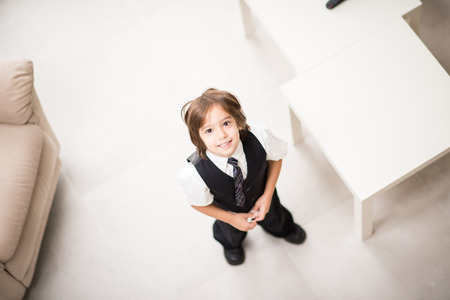 Happy kid with suit and tie at homeの写真素材