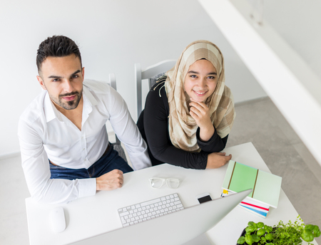 Young mand and woman working in office on computerの写真素材