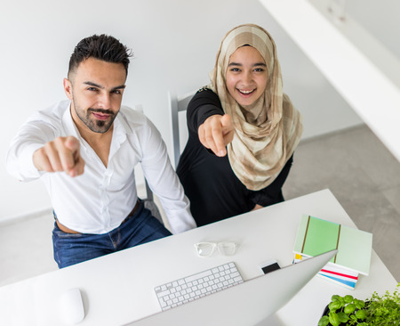 Young mand and woman working in office on computerの写真素材