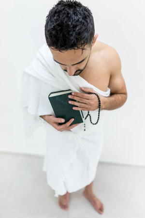 Muslim man posing as ready for Hajj visiting Kaaba in Meccaの写真素材