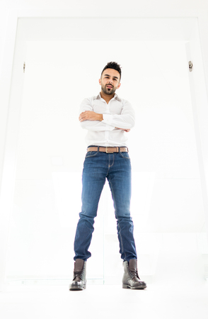 Attractive young man posing in white modern interiorの写真素材