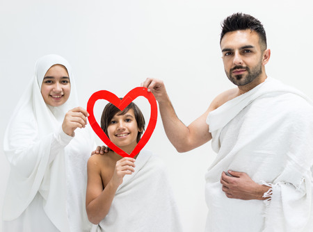 Muslim family posing as ready for Hajj visiting Kaaba in Meccaの写真素材