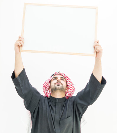 Attractive Arabic young man with white board for your message or textの写真素材