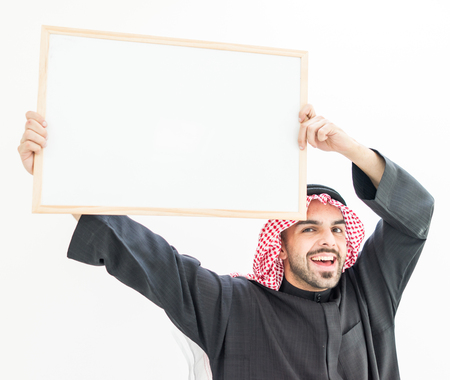 Attractive Arabic young man with white board for your message or textの写真素材