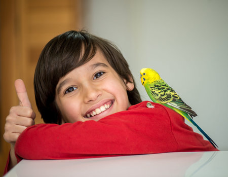 Kid playing with his pet parrot