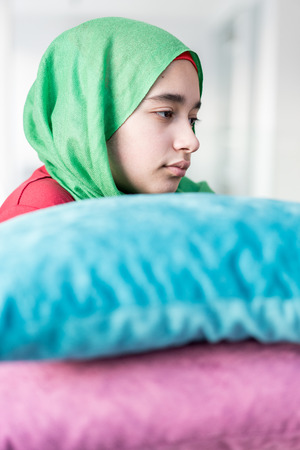 Muslim girl with pillow at homeの写真素材
