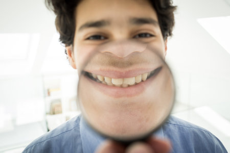 Cute boy with magnifier smiling
