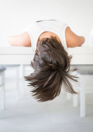 Boy with long brown hair at homeの写真素材