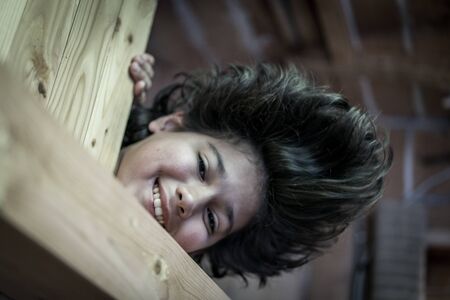 Upside down boy in wooden cottageの写真素材