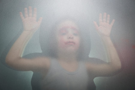 Kid behind glassの写真素材