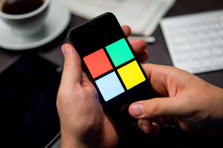 New York, New York / USA - 11 11 2019: Logo of Microsoft Windows on the iPhone X in hands in officeのeditorial素材