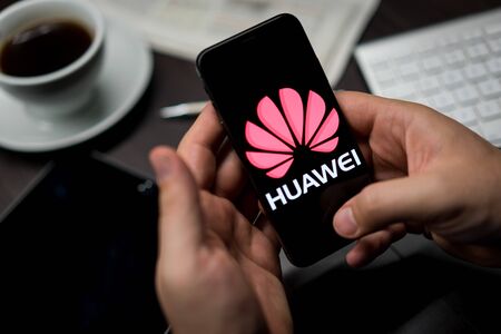 New York, New York / USA - 11 11 2019: Logo of Huawei on the iPhone X in hands in officeのeditorial素材