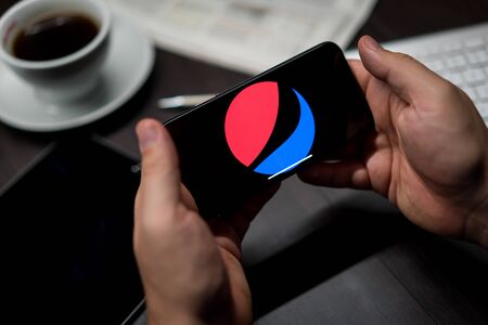 New York, New York / USA - 11 11 2019: Logo of Pepsi on the iPhone X in hands in officeのeditorial素材