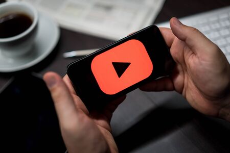 New York, New York / USA - 11 11 2019: Logo of YouTube on the iPhone X in hands in officeのeditorial素材