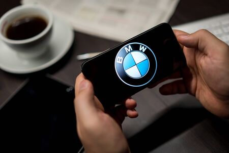 New York, New York / USA - 11 11 2019: Logo of BMW on the iPhone X in hands in officeのeditorial素材